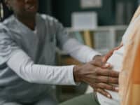 Young Adult Woman Receiving Prenatal Checkup from Black Female Doctor