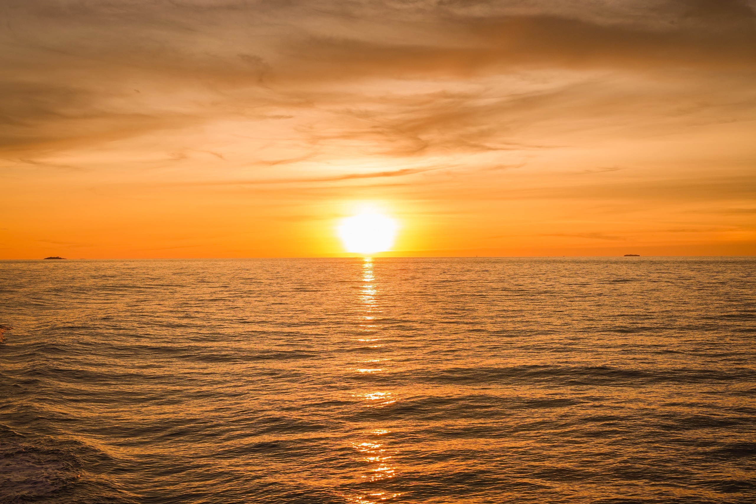 Lens,Flare:,Golden,Sunset,Light,Stretches,Across,Calm,Ocean,Water
